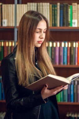 Kütüphanede bir kitap okuyan güzel genç kız öğrenci