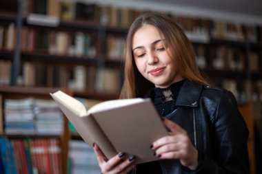 Kütüphanede bir kitap okuyan güzel genç kız öğrenci