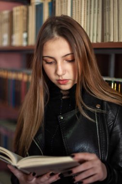 Kütüphanede bir kitap okuyan güzel genç kız öğrenci