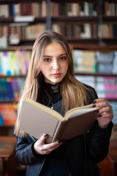 Belle écolière adolescente lisant un livre dans la bibliothèque — Photo