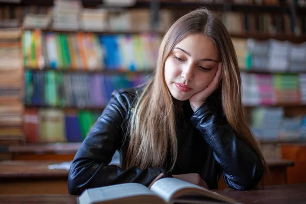 Bela adolescente estudante sentado na biblioteca e leitura — Fotografia de Stock