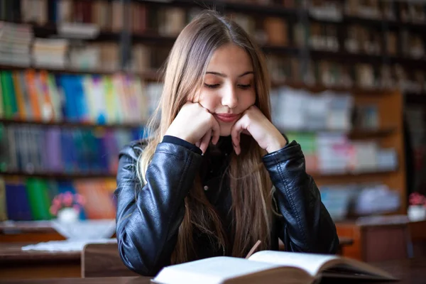 Bela adolescente estudante sentado na biblioteca e leitura — Fotografia de Stock