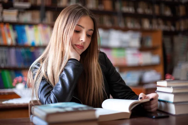 Bela adolescente estudante sentado na biblioteca e leitura — Fotografia de Stock