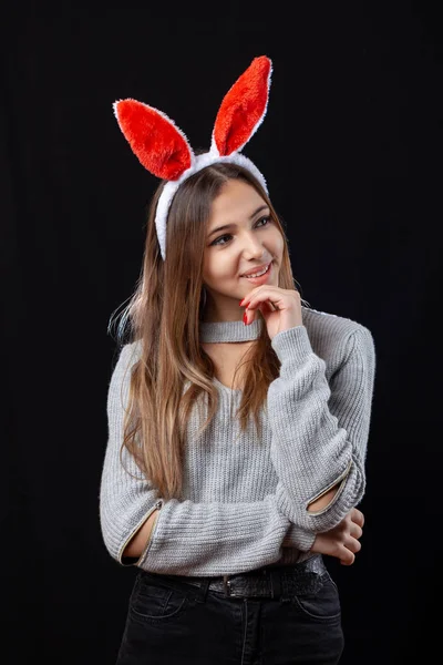 Menina bonita com acessório de coelho posando no fundo preto . — Fotografia de Stock