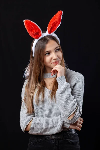 Menina bonita com acessório de coelho posando no fundo preto . — Fotografia de Stock