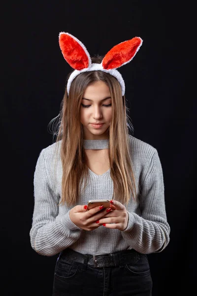 Bella ragazza con accessorio coniglio posa su sfondo nero . — Foto Stock