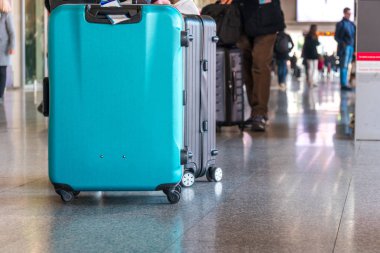 Havaalanında bavul çantasıile tek başına yürüyen yolcu.