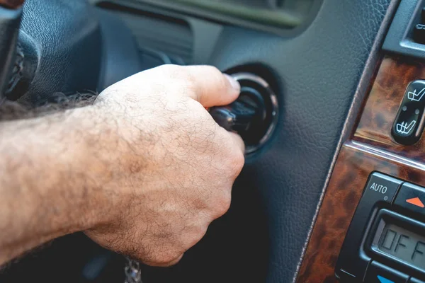 Mãos de homem para pegar as chaves para ligar o carro do motor — Fotografia de Stock