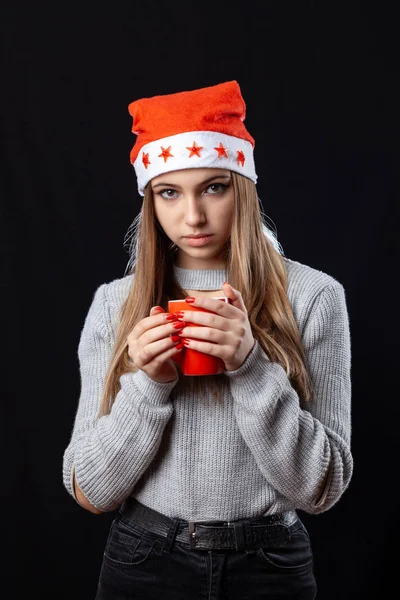 Bella ragazza con una tazza di tè in posa sullo sfondo nero in — Foto Stock