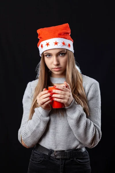 Belle fille avec une tasse de thé posant sur le fond noir dans — Photo