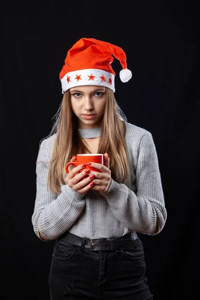 Menina bonita com xícara de chá posando no fundo preto em — Fotografia de Stock