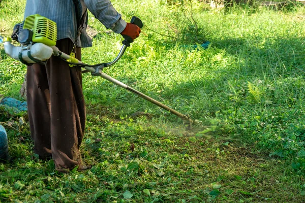 O jardineiro cortar grama por cortador de grama, cuidado do gramado . — Fotografia de Stock