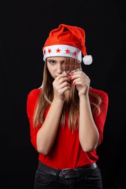 Güzel kız Yeni siyah arka plan üzerinde bir çikolata yeme