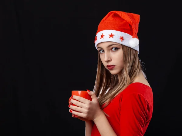 Menina bonita posando com bebida quente em caneca vermelha no bac preto — Fotografia de Stock