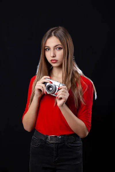 Menina bonita com câmera de estilo antigo posando em camisa vermelha no preto — Fotografia de Stock