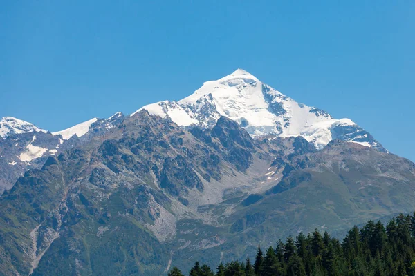 Mount Tetnuldi rises above the Great Caucasian Range in the uppe — Stock Photo, Image