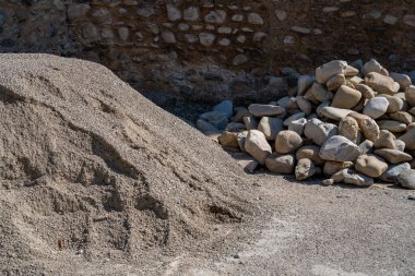 Yolun kenarına yığılmış yuvarlak taşlar yığını.