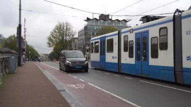 Amsterdam, Hollanda - 14.10.2019: Amsterdam 'da modern tramvayla sokak sahnesi