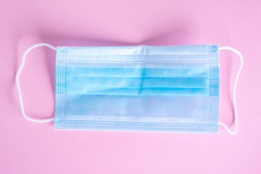 Pembe arka planda izole edilmiş tıbbi koruyucu maske, koronavirüsü engeller.