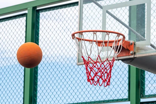 Basketball ring with a net and ball, outdoor playground