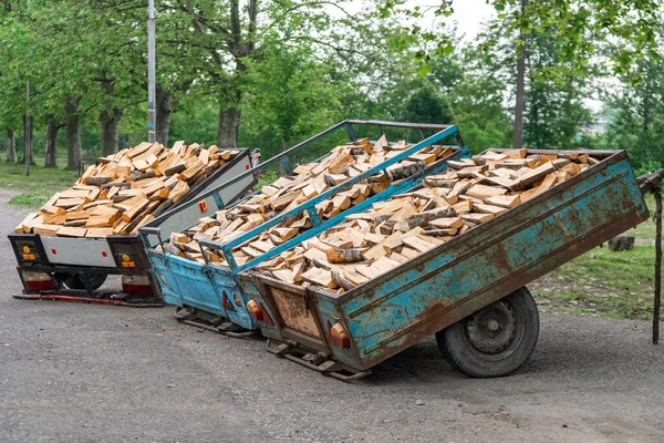 A pile of firewood and logs in an iron truck for sale