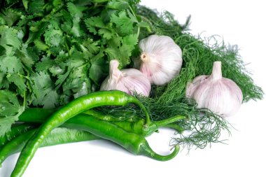 Kişniş, maydanoz, yeşil biber ve sarımsak beyaz arka planda izole edilmiş taze sebze.