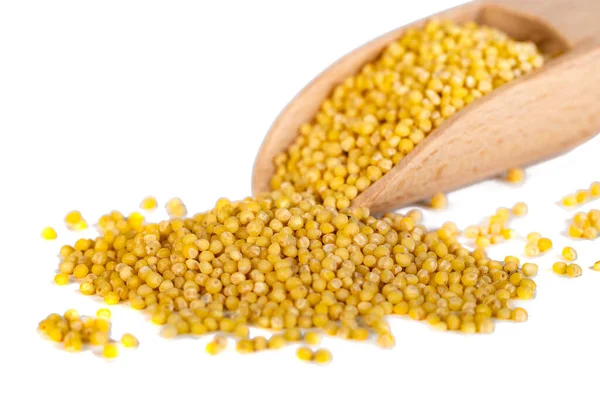 Tahta kaşık, beyaz üzerinde darı var.