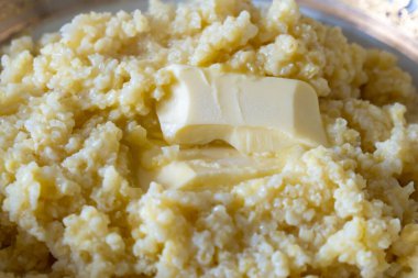 Tereyağlı ve sağlıklı yiyeceklerle süslenmiş darı lapası.