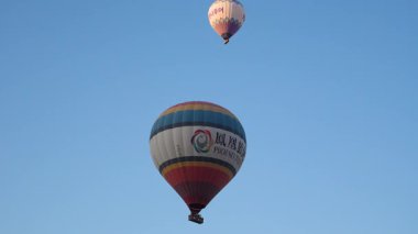 Cappadocia, Turkey - 5 August, 2025: Hot air balloons flying over rocky landscape at sunrise in Cappadocia. Travel
