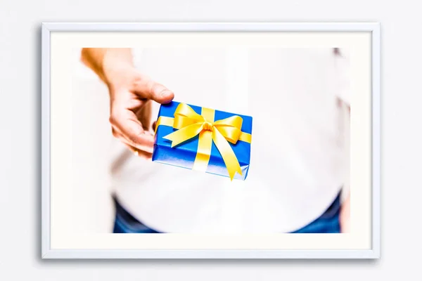 Αρσενική χέρι που κρατά μια μπλε συσκευασία δώρου με κορδέλα. — Φωτογραφία Αρχείου