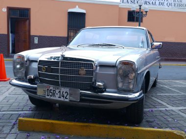 Lima, Peru. 4 Aralık 2016. Ön ve yan görünümü bir nane koşulu ışık mavi Mercedes-Benz 280c Coupe. Bu araba Almanya'da Daimler-Benz Ag tarafından 1972 ve 1976 arasında inşa edilmiştir. Pueblo Libre bölgesinde bir eski model araba toplantıda sergilendi 