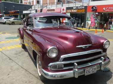 Lima, Peru. 24 Mart 2016. Ön ve yan bir Bordo renk nane ve olağanüstü durum Chevrolet De Luxe coupe General Motors tarafından 1951 yılında inşa görüntüleyin. Güzel ve güneşli bir günde bir benzin istasyonunda Lima San Isidro bölge araba mı.