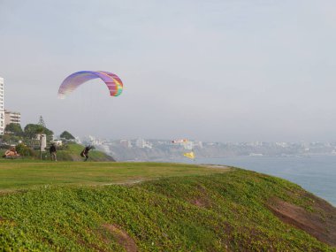 Lima, Peru. 23 Ekim 2017. Bir pilot yamaçparaşütü renkli bir yok motoru çok atlama ve Miraflores sahil turistik Lima taslağı üzerinde uçuruma Raymondi Parkı uçmak hazırdır