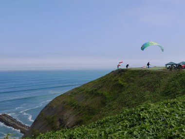 Lima, Peru. June 14, 2016. Pilot in a no engine paraglider is ready to jump and fly from Raymondi park on the coast of Miraflores touristic district of Lima clipart