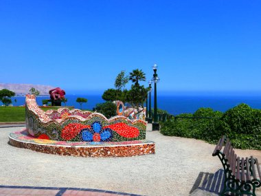 Lima Miraflores turistik bölge Pasifik Okyanusu'na bakan çok renkli kiremitli tezgah El Parque del Amor (The Love Park) doğal görünümünü. Pasifik Okyanusu, mavi gökyüzü ve su ufukta görülebilir