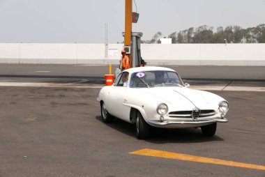 Lima, Peru. November 11, 2017. Front and side view of a mint condition white color Alfa Romeo Giulietta Sprint Speciale Bertone coupe. This car was built in Italy by Alfa Romeo in 1960. The photo was taken at south of Lima in a gas station clipart