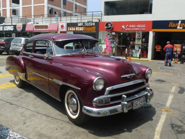 Lima, Peru. 24 Mart 2016. Ön ve yan bir Bordo renk nane ve olağanüstü durum Chevrolet De Luxe coupe General Motors tarafından 1951 yılında inşa görüntüleyin. Güzel ve güneşli bir günde bir benzin istasyonunda Lima San Isidro bölge araba mı.  