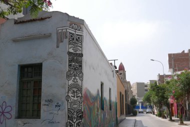 Lima, Peru. 19 Mayıs 2018. Çok renkli dekoratif duvar yazısı ile klasik ev duvarları Barranco hippi Lima bölge boyanmış. Resimdeki sokak, bir yaya yolu, ağaçlar, açık bir gökyüzü ve evler vardır