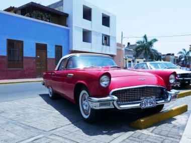 Lima, Peru. 4 Aralık 2016. İlk nesil Ford Thunderbird Coupe V8 motoru ile bir kırmızı ve beyaz renk ön ve yan görünümünü 1955 ve 1957 yılında ABD'de Ford Motor şirketi arasında inşa ve Lima Pueblo Libre bölge sergiledi