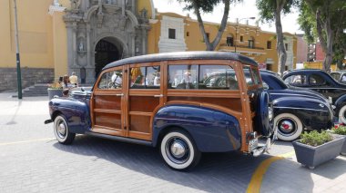 Lima, Peru. May 6, 2018. Rear and side view of an old blue Ford Super DeLuxe Woodie Station Wagon built in 1941 by Ford Motor Company in the USA. This vehicle was exhibited in a retromobile meeting in Barranco district of Lima on a sunny day  clipart