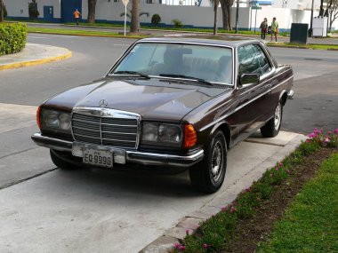 Lima, Peru. 6 Kasım 2010. Ön ve yan görünümü bir kahverengi renk Nane koşulu Mercedes-Benz 230 Ce Coupe Lima San Isidro İlçe Park. Bu model Mart 1977 ve 1986 arasında Almanya'da üretildi.