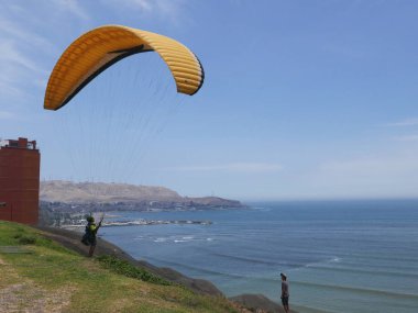 Lima, Peru. 9 Şubat 2017. Lima Barranco ilçe scenical görünümünden güneyde Lima Körfezi ve atlama ve bir paraglide ile uçmak için küçük bir alan. Resimdeki ortada bir uçurum, tanınmayan bir pilot bir yamaçparaşütü ve Pasifik Okyanusu ile
