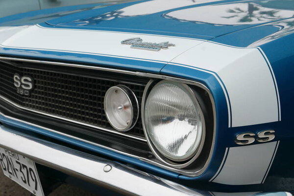 Lima, Peru. February 17, 2018. Close up of the front and side view of a blue and white color skill condition Chevrolet Camaro SS 350 built in 1967 by General Motors in the USA. The image was taken in Chorrillos district of Lima on a sunny day.