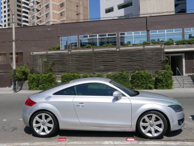Lima, Peru. April 15, 2017. Side view of a parked silver color Audi TT RS coupe. In the image there is a built structure. This photo was taken in Miraflores district of Lima on a beautiful and sunny day  clipart