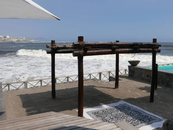 Scenic view of the Pacific Ocean from a holiday house at coastline and a beach wood umbrella in Pulpos beach located 41 kilometers south of Lima.