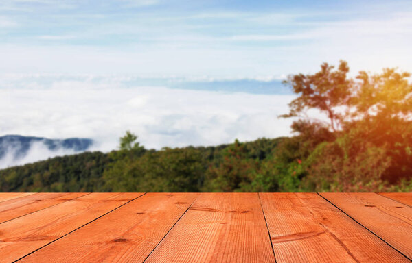 brown wooden board on mountain with blur clouds and forest
