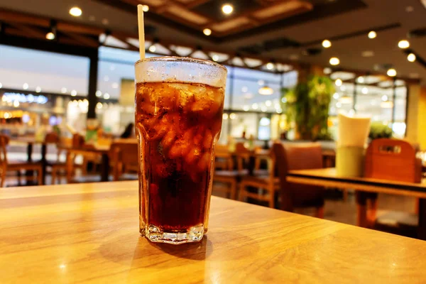 glass of cold fizzy drink on table