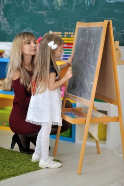 Anne ve kızı tahtaya çizmek.