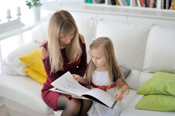 Beautiful mother and daughter read a book.