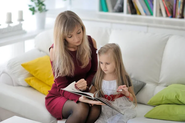 Beautiful mother and daughter read a book.